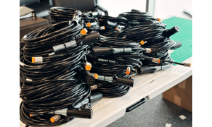 Coiled industrial wire harness assemblies with multi-pin connectors on workbench