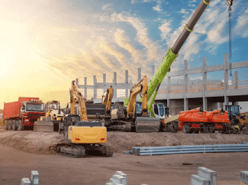 Construction site with excavators, crane, and heavy machinery working on a large building project