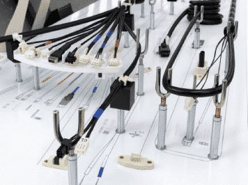 Engineered wire harnesses with multiple connectors mounted on a custom assembly board for industrial applications