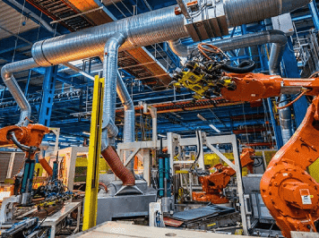 Automated industrial manufacturing line with robotic arms operating inside a factory facility